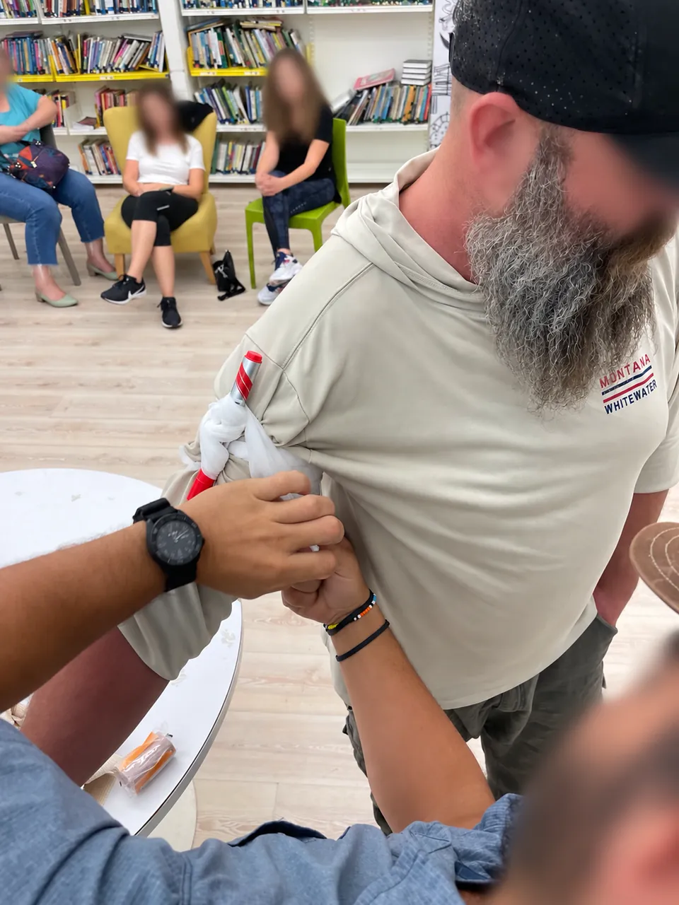 Hands-on emergency-care training demonstration, with faces blurred.